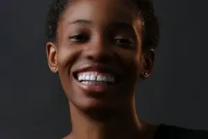 Woman smiling, dark background